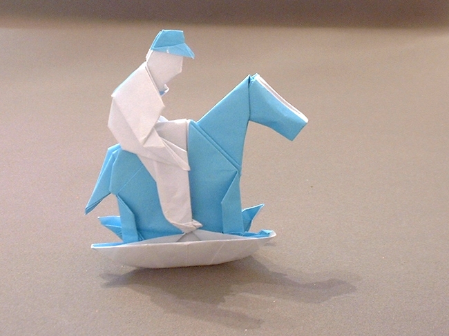 Origami Boy on a rocking horse by Neal Elias. Folded from a square of origami paper by Gilad Aharoni on giladorigami.com