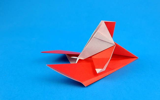 Origami Santa on skis by Aoyagi Shoko. Folded from a square of origami paper by Gilad Aharoni on giladorigami.com